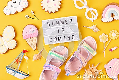 Summer is coming. Motivational quote on lightbox and cute summer symbols on yellow background. Top view, Flat lay. Creative Stock Photo