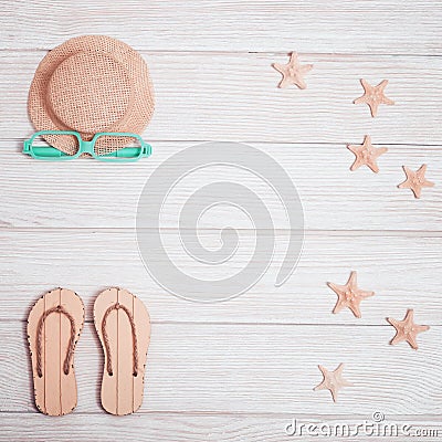 Summer composition, beach slippers, straw yellow hat, starfish, sunglasses on white wood, summer background Stock Photo