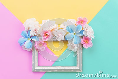 Summer composition. Empty frame and flowers flat lay on yellow, green and pink pastel background with copy space Stock Photo