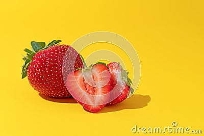 Summer composition fruits, berries. Two of freshly ripened strawberries on a yellow background Stock Photo