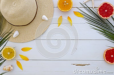 Summer composition. Fruits, hat, tropical palm leaves, seastones on pastel yellow white wooden background. Summer Stock Photo