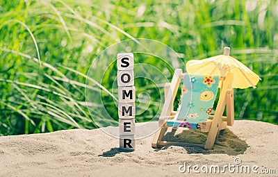 Summer concept. Dice placed on a beach form the German word `sommer` Stock Photo