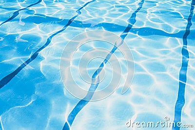 Summer day at swimming pool. Background and texture concept. Ripple Water in swimming pool with sun reflection. Stock Photo