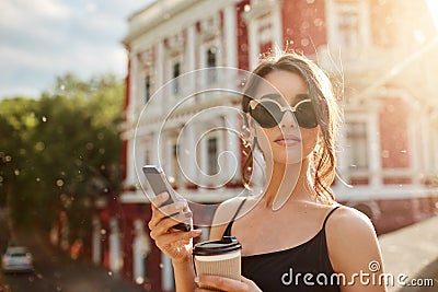 Summer days. Close up portrait of attractive skinny feminine caucasian woman with dark hair in tan-glasses and black Stock Photo