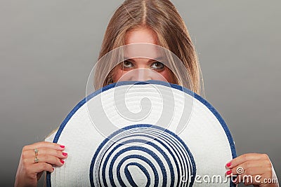 Shy woman hiding behind sun hat Stock Photo