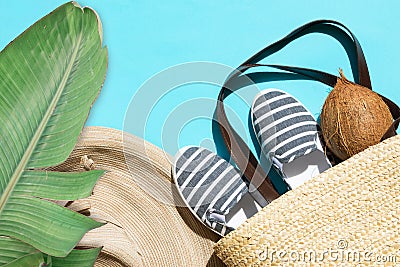 Summer fashion tropical concept. Women`s female beachwear straw hat wicker bag canvas striped shoes coconut green palm leaf Stock Photo