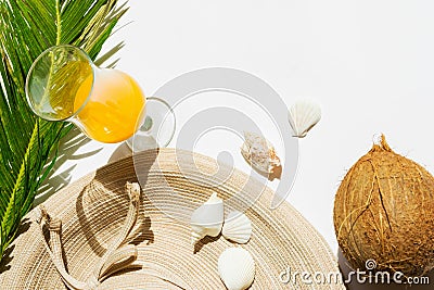 Summer fashion tropical vacation travel concept women`s beachwear straw hat coconut cocktail glass of fruit juice green palm leaf Stock Photo