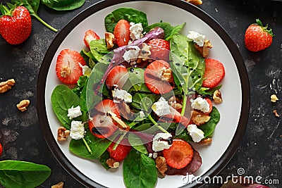 Summer Fruit Strawberry, spinach Salad with walnut, feta cheese balsamic vinegar, kale. in a plate. concepts health food Stock Photo