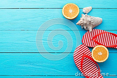 Summer fun time and flip flops. Sea shell. Slippers and orange fruit on blue wooden background. Mock up and picturesque. Top view. Stock Photo