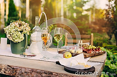 Summer garden table decorated with flowers and candles, evening party with wine Stock Photo