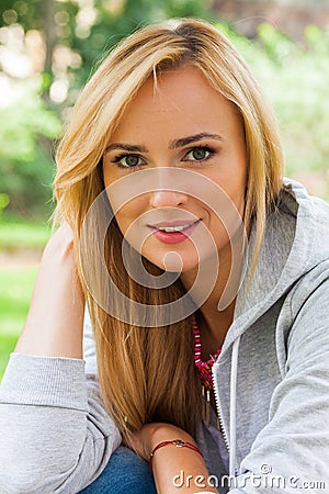 Summer girl portrait. Caucasian blonde woman smiling happy on sunny summer or spring day outside in park. Stock Photo