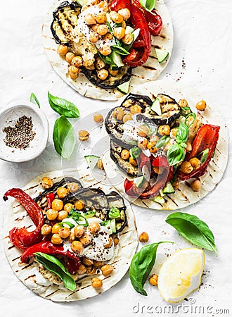 Summer grilled garden vegetables and spicy chickpeas vegetarian tortillas on a light background, top view. Healthy food picnic Stock Photo