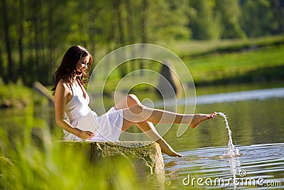 Summer - Happy romantic woman sitting by lake Stock Photo