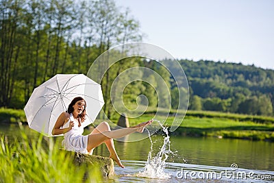 Summer - Happy romantic woman sitting by lake Stock Photo