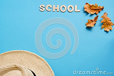 Summer hat and dry oak leaves with Woody school inscription. back to school or kindergarten. summertime, creativity and learn Stock Photo