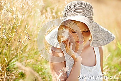 Summer, hat and relax with woman in field for travel, vacation and holiday. Thinking, peace and nature with female Stock Photo