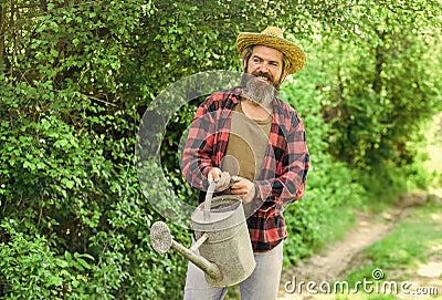 Summer heat. Equipment in farmers hands. Rustic style. Saturate soil with nutrients. Man hold big watering Man with Stock Photo