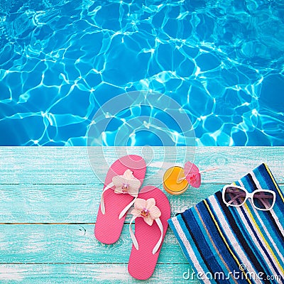 Summer Holidays in Beach Seashore. Fashion accessories summer flip flops, hat, sunglasses on bright turquoise board near the pool Stock Photo