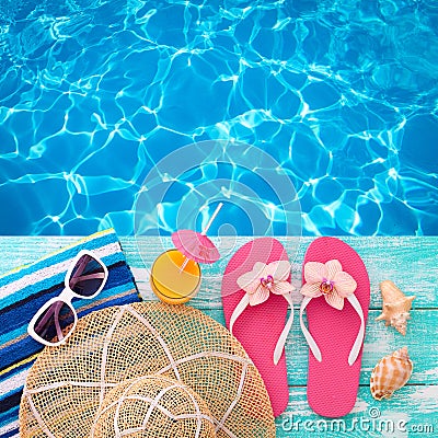 Summer Holidays in Beach Seashore. Fashion accessories summer flip flops, hat, sunglasses on bright turquoise board near the pool Stock Photo