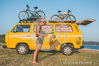 Young hippie women in front of minivan car on beach Stock Photo