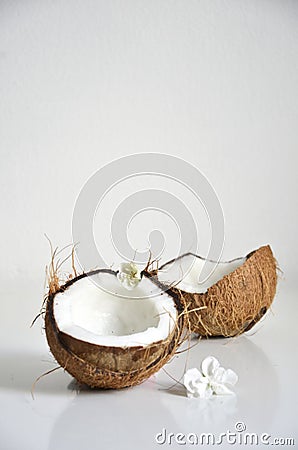 Summer image of a coconut slpit in half white flowers. Summer fruit concept Stock Photo