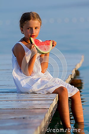 Summer joy, lovely girl eating fresh watermelon on the beach Stock Photo