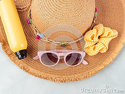 Summer lady straw hat, yellow sun protection spray and sunglasses on turquoise stone background. Stock Photo