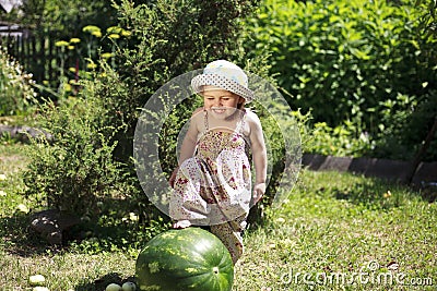 Summer, little girl steps on a watermelon, Stock Photo