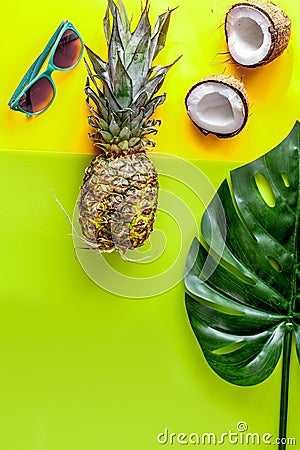 Summer mix with sun glasses, pineapple and coconut yellow background top view mockup Stock Photo