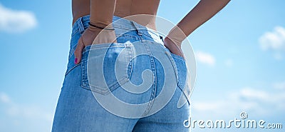 Summer mood. Topless. The girl in jeans. Buttocks. Sexy ass. Girl against the sky, rear view. Stock Photo