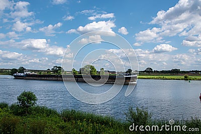 Summer morning - a dutch dike landscape at the river Maas with boat. Agricultural landscape Editorial Stock Photo