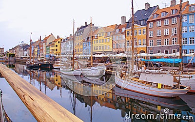 Summer morning view of Nyhavn pier with color buildings, ships, yachts and other boats in the old part of town of Copenhagen, Editorial Stock Photo