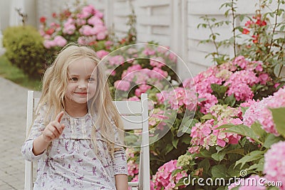 Summer. Mothers or womens day. Little girl at blooming flower. Childrens day. Small baby girl. Spring flowers. Childhood Stock Photo