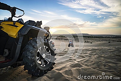 Summer offroad adventure on atv in sand quarry. Entertainment of tourists in desert in MUI ne in Vietnam. Off-road ATV wheel close Stock Photo