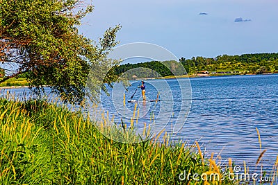 Summer in Omaha, Isolated paddle boater at water`s edge at Ed Zorinsky lake park, Omaha, Nebraska, USA Stock Photo