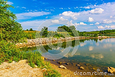 Summer in Omaha, Panorama Shoreline and sky reflections in the lake at Ed Zorinsky Lake Park Omaha NE Stock Photo