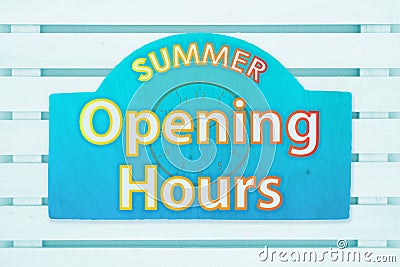 Summer Opening Hours type message with a sun on a green wood sign Stock Photo