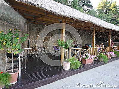 Summer outdoor cafe near the square on a reed roof terrace Editorial Stock Photo