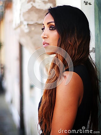 Summer outfit - African Italian woman, dressed with black and bronze dress, waiting. Stock Photo