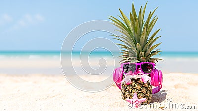 Summer in the party. Hipster Pineapple Fashion in sunglass and listen music on the sand beach beautiful blue sky background. Stock Photo