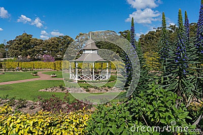 Summer pavilion in public garden with lush spring plants Stock Photo