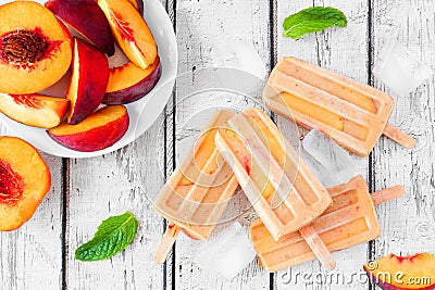 Summer peach yogurt popsicles, top view table scene against white wood Stock Photo