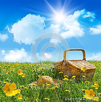 Summer picnic basket with straw hat in a field Stock Photo