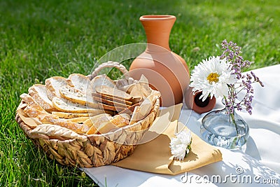 summer picnic on the green grass. clay jug and bread Stock Photo