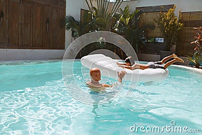 Summer Pool. Father And Son Enjoying Sunny Day. Little Boy Floating On Inflatable Water Mattress. Stock Photo