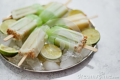 Summer refreshing homemade lime popsicles with chipped ice over stone background Stock Photo