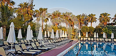 Summer resort: swimming pool and chaise loungues Stock Photo