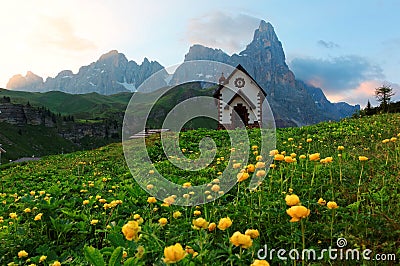 Summer scenery of Dolomites with view of a lovely church at the foothills of rugged mountain peaks Cimon della Pala Stock Photo