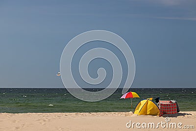 Summer scenery, sunny beach. Umbrella and beach tent. Sandy coastline Stock Photo