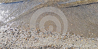 Summer sea background. Transparent sea wave rolls on the sandy beach Stock Photo